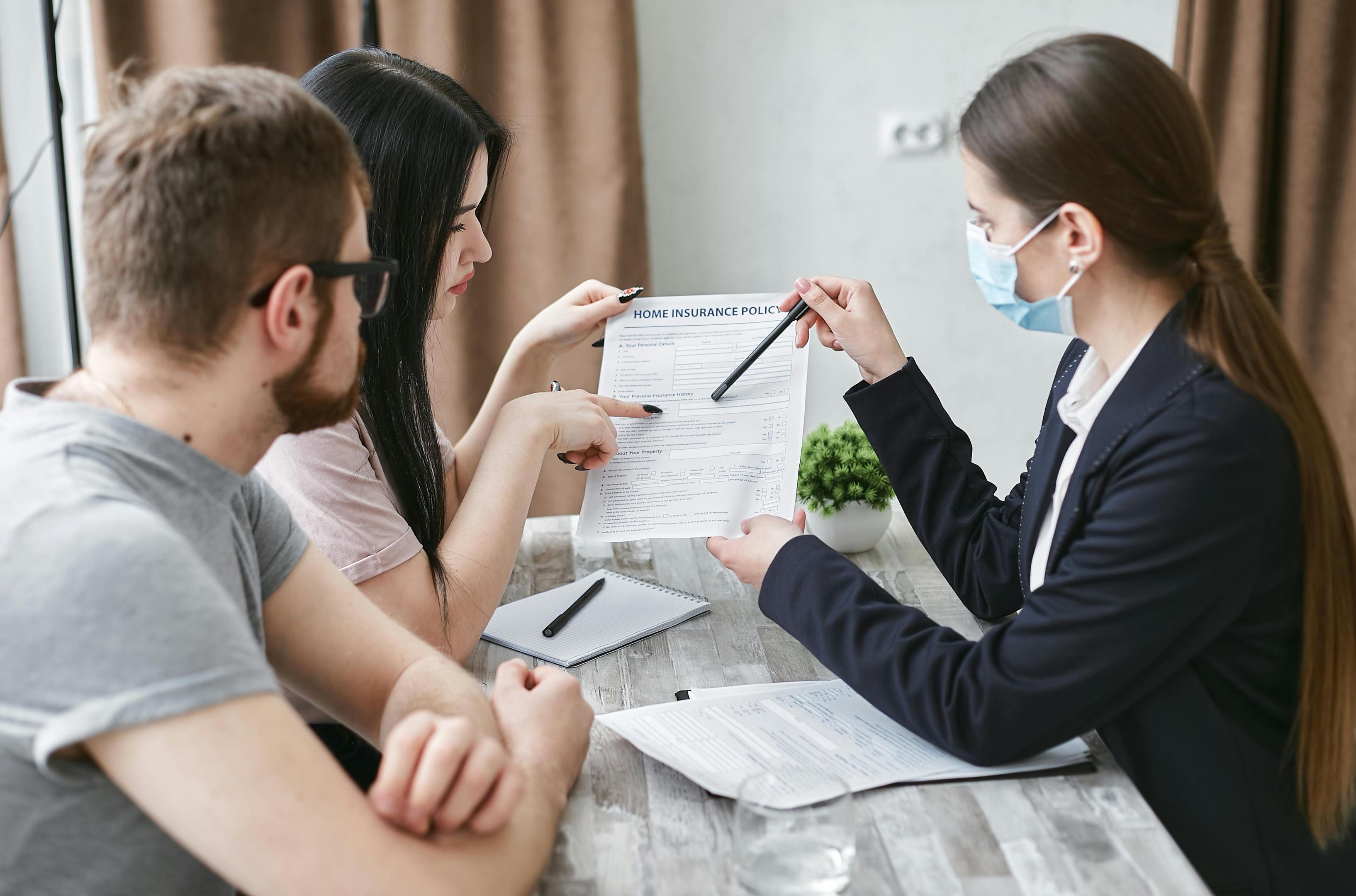 An admissions team rep goes over insurance paperwork with a couple